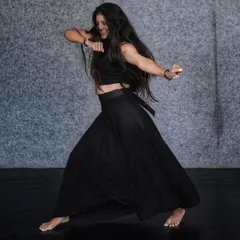 A powerful, grounded stance from an Indian Contemporary routine. This form of dance builds strength, flexibility, and expressive capability.