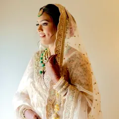 A side profile capturing the complete bridal look. The soft glam makeup and elegant dupatta draping come together to create a vision of timeless grace for her special day.