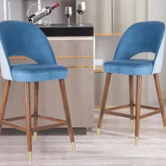 These wooden bar stools feature a comfortable, upholstered seat in blue fabric and gold-tipped legs. They are perfect for adding a pop of color to a kitchen counter or bar.