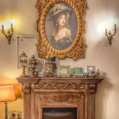 The fireplace is the heart of the cafe, and the vintage-style portrait above it adds to the old-world charm. It’s a perfect backdrop for a cozy conversation, especially on a rainy day.