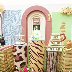I love how this 'Wild One' safari theme came together for a first birthday. We used multiple themed backdrops, animal print plinths, and fun props like the jeep cutout to create a truly immersive jungle experience for the little one and the guests.