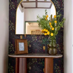 Another view of the 'Modern Muse' foyer, where the dark floral wallpaper and custom console table create an elegant and inviting entryway.