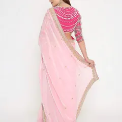 The back of this blouse is made for divas! The stunning pearl detailing on this magenta blouse adds a modern and glamorous touch to the soft pink saree.