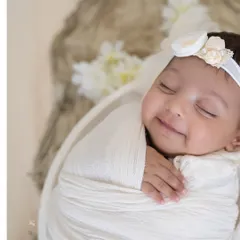 That sleepy newborn smile is one of the most precious things in the world. In this minimalist newborn portrait, I used soft, natural-looking light and a simple white swaddle to focus entirely on her serene expression. These are the fleeting moments I love to freeze in time.
