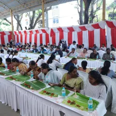 A wide view of a large wedding reception with guests seated in long rows, enjoying our traditional banana leaf catering. We are equipped to handle events of any scale, ensuring every guest is well-fed.