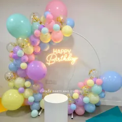 A beautiful pastel balloon ring with a 'Happy Birthday' neon sign. This setup uses a mix of soft colors and confetti balloons for a celebratory feel.