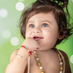 A beautiful close-up of a baby with stunning blue eyes, dressed as Krishna. A truly mesmerizing and soulful portrait.
