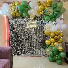 The sequin wall backdrop placed in a living room, showing how it can transform a home space for a party.