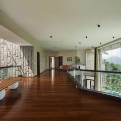The upper-level bridge in this mountain home connects different living zones while maintaining a sense of openness. We used rich hardwood flooring and a glass railing to ensure that the breathtaking views through the floor-to-ceiling windows remain the primary focus.