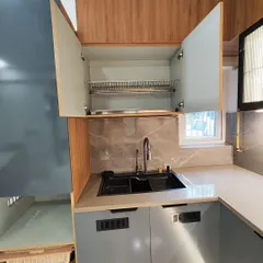 Smart storage is key in a modern kitchen. This image shows a dish rack installed in an overhead cabinet, a simple solution that keeps the counter clear and organized.