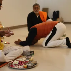 A student bows in reverence during the Diksha ceremony, an act of surrender to the teachings and the lineage. This humility is essential for receiving the profound knowledge of yoga.
