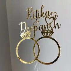 Celebrate your engagement with a design that says it all. This "Ritika & Deepansh" topper features interlocking rings and elegant script, making it a popular choice for couples starting their new journey.