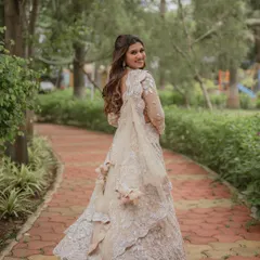 A lovely "look back" portrait of the bride as she walks through a green park. Her smile is infectious, and the shot beautifully captures the flow and detail of her white embroidered gown.