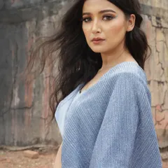 A designer shoot against a rustic, architectural backdrop. I styled this blue jumpsuit with a unique silhouette to create a strong contrast with the textured, earthy tones of the location.