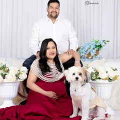 Including your fur baby in your maternity shoot is a wonderful idea. This studio portrait features a couple with their adorable dog, creating a complete family picture.
