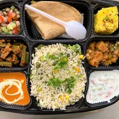 A wholesome vegetarian thali prepared for a Diwali pooja lunch. This meal includes Paneer Butter Masala, Bhindi Masala, Babycorn Manchurian, Veg Pulao, Raita, Peanut Kachumber, Dhokla, and a soft Phulka.