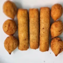 A platter of crispy fried starters, including spring rolls and vegetable cutlets, perfect for kicking off any party.
