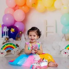 The joy on her face says it all. This shot captures the moment she realizes the cake is all for her, surrounded by a pastel rainbow of balloons.