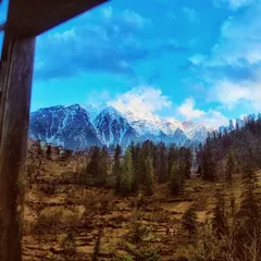 A view of the snow capped Himalayas from a window in a rustic wooden room. This frame captures the feeling of waking up to the mountains, a simple happiness that I find in Himachal.