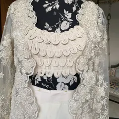 A close-up of the scalloped, textured blouse and the hand-embroidered jacket. This outfit is a true head-turner.