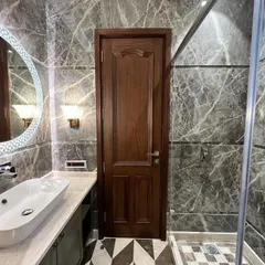 This bathroom is all about drama and luxury. We've used floor-to-ceiling grey Italian marble, a custom vanity with a vessel sink, and a large, backlit mirror to create a truly immersive, spa-like experience.