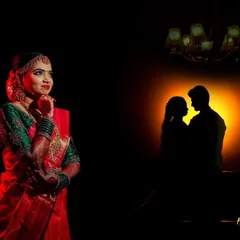 A dramatic and artistic bridal portrait. The use of shadow and a silhouetted couple in the background tells a story of love and anticipation.