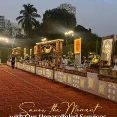 An expansive outdoor buffet setup under the evening sky. We ensure our service is unparalleled, creating a seamless and memorable dining experience for every single guest at your celebration.