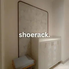A custom entryway unit designed for style and function. This piece includes a shoe cabinet with patterned doors, a comfortable seating bench, and a large decorative panel that adds an artistic touch.