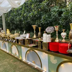 This is the standard we bring to every outdoor wedding celebration. A sprawling buffet line featuring elegant, modern counters with gold accents, premium chafing dishes, and tasteful decor, all set up to create a stunning visual feast for your guests.