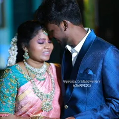 A romantic photo of the couple at their reception. The bride's glamorous makeup and jewellery look stunning against the groom's sharp blue suit.