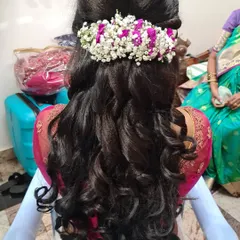 A beautiful half-up, half-down hairstyle with soft waves. Fresh baby's breath and purple flowers are woven in for a romantic and elegant touch.