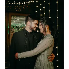 A classic romantic portrait from the Sangeet night. The couple embraces under the soft glow of fairy lights, lost in a moment of quiet intimacy amidst the celebration.
