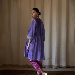 Capturing a moment of quiet reflection for Bellerobe. The soft pleats and rich purple of the kurta are the focus, with the simple curtain backdrop creating a calm, harmonious atmosphere for this modern ethnic wear piece.