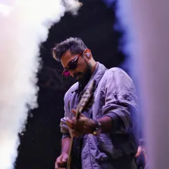 I work with the elements of the stage, using smoke and dramatic lighting to frame the musician. This shot captures the atmosphere of a live show, where the music itself feels visible.