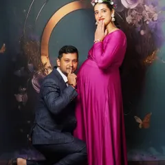 A playful pose from the same maternity shoot, showing the dad-to-be sharing a secret with the baby.
