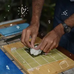 The foundation of great sushi is perfectly prepared rice. Here, a participant carefully presses the seasoned rice onto a sheet of nori, getting the texture and distribution just right.