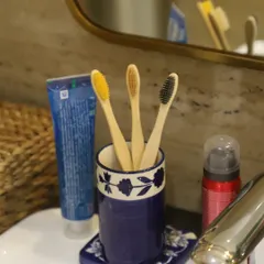 Our bamboo toothbrushes, seen here in a stylish bathroom setting, are a simple way to make your daily routine more sustainable. The different colored bristles help family members tell their brushes apart.