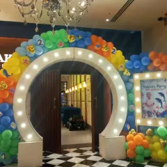 This lit-up circular arch makes for a fantastic entrance and photo opportunity. We surrounded it with a colorful sea-themed balloon garland and a personalized light-up photo frame for a kid's party, and can customize this design for any wedding theme.