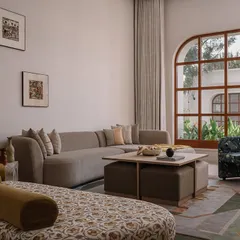 This is the parents' suite at our Rehethaan project. The family room is defined by a serene palette of ivories and ochres, with custom-designed sofas and a patterned chaise lounge creating a comfortable and elegant living space.