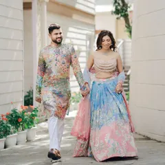 A lovely walking shot of a couple during their Mehndi ceremony. The groom's colorful kurta and the bride's pastel lehenga create a beautiful, vibrant picture of happiness.