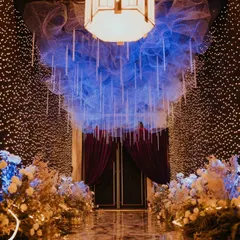 A closer view of the starry sangeet entrance. The ceiling is a cloud of blue mesh with hanging crystal strings, while the walls are covered in a dense curtain of warm fairy lights, creating a breathtaking and immersive experience.