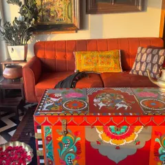 The vibrant colors and detailed artistry of this restored trunk are captured in the warm sunlight. The design features Uma Maheshwar on Nandi, a classic theme from temple art, reimagined to create a unique and functional heirloom.