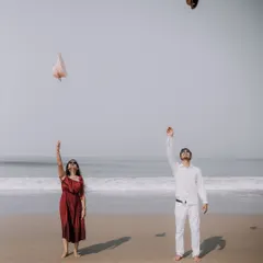 A fun, carefree moment as the couple throws their hats in the air on the beach. This shot captures a sense of freedom and joy.
