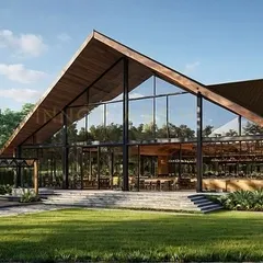 An exterior view of The Bliss Banquet, showing how the structure integrates with the surrounding landscape. The design includes an outdoor seating area under a pergola, extending the functional space and connecting the modern architecture with nature.