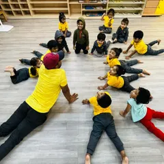 I lead a group of preschoolers in a simple cobra yoga pose, making warm-ups fun and engaging. These sessions are designed to build flexibility and a positive connection with their bodies from an early age.