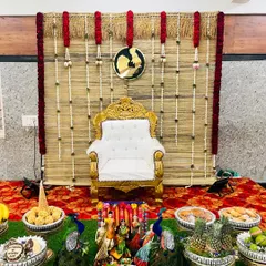 A rustic and elegant Seemantham decor featuring a backdrop made of natural bamboo blinds, adorned with simple floral garlands.