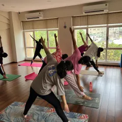 Expecting mothers practice Trikonasana, or Triangle Pose, in our sunlit studio. This standing pose is wonderful for creating length in the side body, opening the hips, and building stability in the legs.