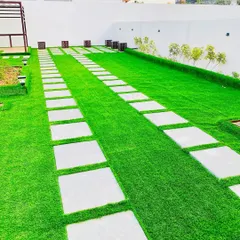 For this large outdoor space, we laid long strips of artificial turf separated by clean, white stone pavers. This creates a neat, manicured look that is perfect for walkways in commercial or residential complexes.