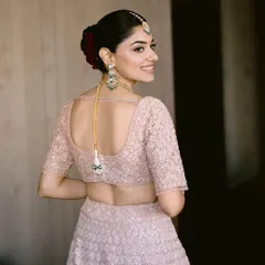 A beautiful back profile of the bride, showing off her elegant hairstyle and the delicate details of her blouse.