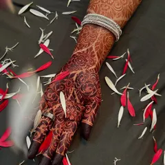 A close-up of a gorgeous, dark henna stain on the hand and wrist. The floral patterns look even more stunning once they've fully developed.